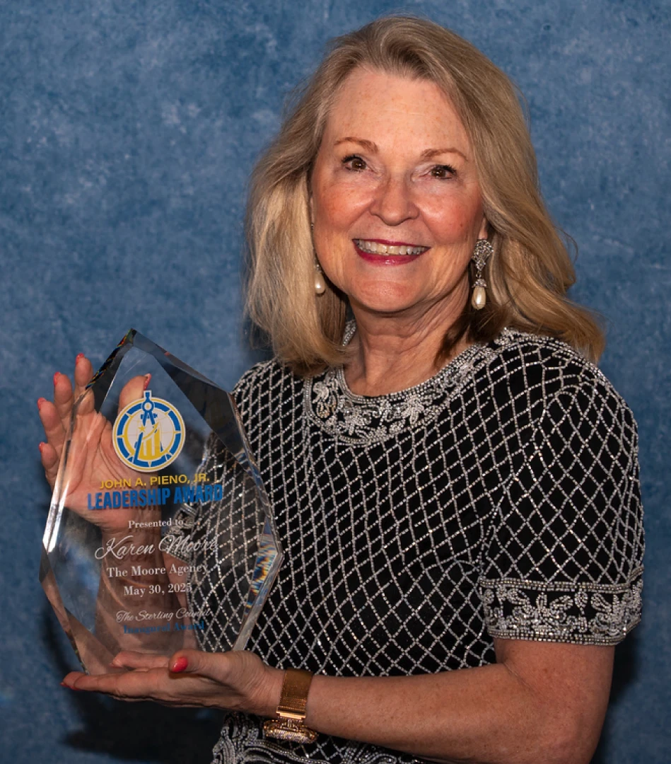 Karen Moore holding the John A. Pieno, Jr. Leadership Award